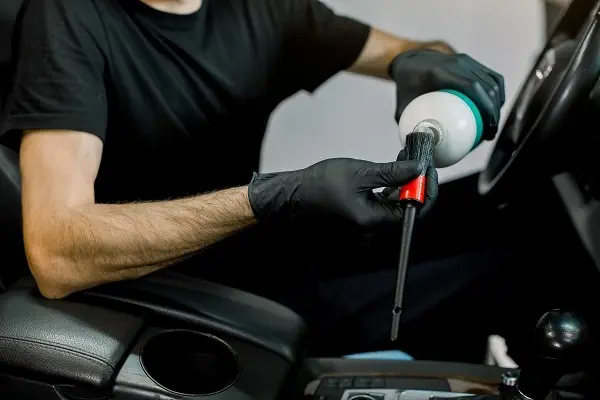 Fresno car owner checking questions to ask before hiring detailer for premium auto care.