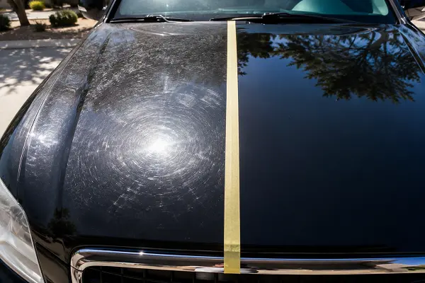 Before and after paint correction showing swirl marks removed and gloss restored on black car paint.