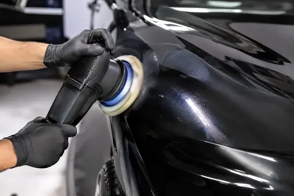 Professional paint correction in Fresno using a machine polisher to remove swirl marks from car paint.
